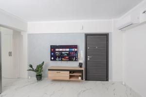 a living room with a wooden cabinet and a wall at Casa di Vila in Rethymno