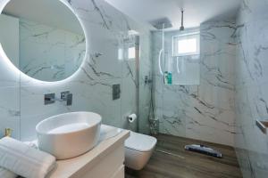 uma casa de banho com um lavatório, um WC e um espelho. em Casa di Vila em Rethymno Town