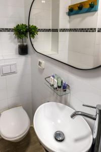 a bathroom with a white sink and a toilet at Domus Bat Galim Hotel in Haifa