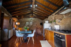 una cucina con un tavolo e sedie in una stanza di Casa do Charco Peneda Gerês a Parada Altre 42 foto