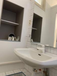 Baño blanco con lavabo y espejo en Grand Studio indépendant, en Pignan