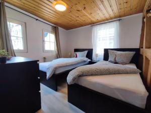two beds in a room with two windows at FeWo Innenstadt mit Dachterasse, Grill, bis 8 Personen, 3 SZ in Cochem