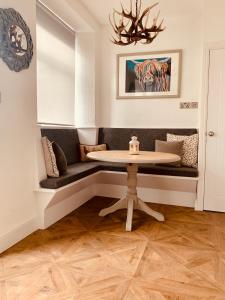a dining room with a table and a bench at Woodland Cottage - cosy dog friendly cottage in the heart of Windermere in Windermere