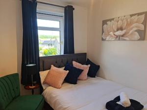 a bedroom with a bed with a window and a couch at Green Apartments in Invergowrie