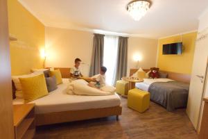 zwei Kinder auf einem Bett in einem Hotelzimmer in der Unterkunft Gästehaus Zehmerhof bei Erding in Walpertskirchen