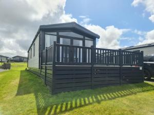 a house with a screened in porch on the grass at Mawgan Pads Perranporth in Cubert