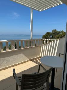 balcón con mesa, sillas y vistas al océano en Stipe Residence, en Podstrana