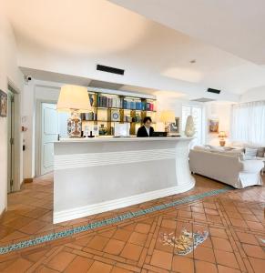 a woman standing at a bar in a living room at Regina Cristina in Capri