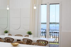 a dining room with a table and chairs and a window at Quilungomare in Porto Cesareo