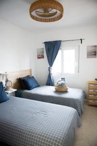 a bedroom with two beds with blue sheets and a window at Casa de Almano - Torremolinos direct on beach in Torremolinos