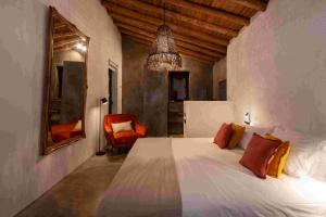 Un dormitorio con una cama blanca y una silla roja. en Vigias -Eternal Landscapes, en Marvão