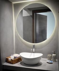 a bathroom with a bowl sink and a mirror at Maro Sweet Home in Aigio