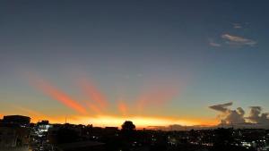 um pôr-do-sol com um arco-íris no céu sobre uma cidade em Apartamento inteiro dois quartos próximo ao Centro em Manaus