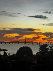 a sunset with a bridge in the water at Apartamento inteiro dois quartos próximo ao Centro in Manaus