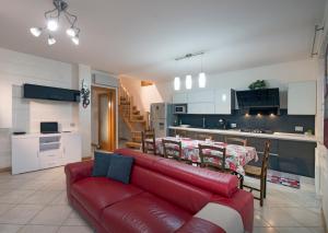 sala de estar con sofá rojo y cocina en Casa vacanza Simona, en Salionze