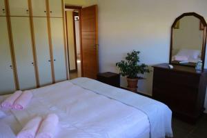 a bedroom with a bed and a dresser and a mirror at sissy's relaxing villa in Artemida