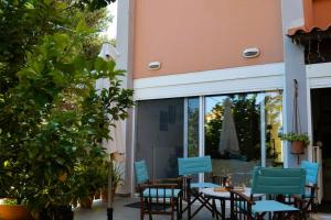 a patio with blue chairs and a table and a window at sissy's relaxing villa in Artemida