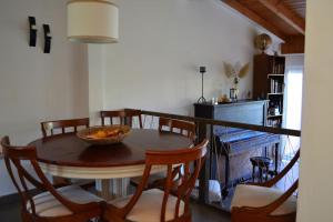una mesa de comedor con sillas y un bol de fruta. en sissy's relaxing villa, en Artemida