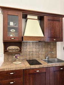 a kitchen with wooden cabinets and a sink at Vicolo 35 Apartments in Trapani +47 photos
