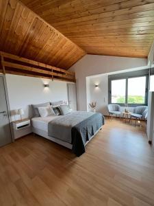 a bedroom with a large bed and a wooden ceiling at Koroni Luxury Maisonette in Koroni