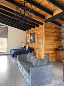 un soggiorno con un divano e un letto di Cabaña Turemsa a Mazamitla