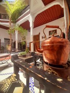 une grande bouilloire en cuivre assise sur une table dans un bâtiment dans l'établissement Riad Chennaoui, à Marrakech