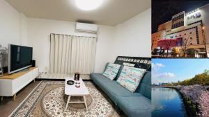 un soggiorno con un divano blu e una TV di 竹苑（一戸建て）露天温泉歩い1分間・梅田まで12分・天神橋六町目歩いて7分間 ad Osaka