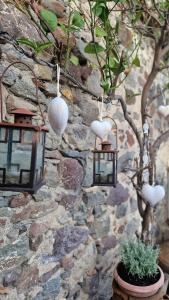 a stone wall with two hanging lanterns and a tree at Afroditi's 2 in Eresos