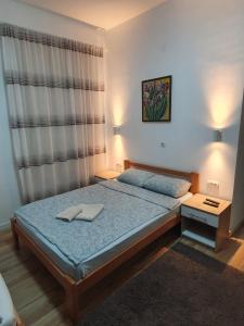 a bedroom with a bed with a blue bedspread and a window at STUDIO VIK in Soko Banja