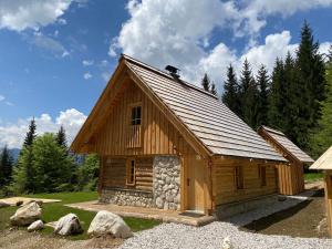 una pequeña cabaña de madera en un campo con árboles en Lovely Cottage in a mountain wilderness of the National Park en Srednja Vas v Bohinju