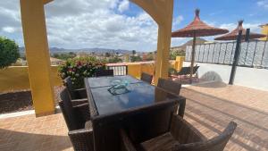 a patio with a table and chairs and an umbrella at Casa Sandia in Mazarrón