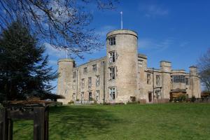un antiguo castillo con una torre en un campo de hierba en Best Western Walworth Castle Hotel en Darlington