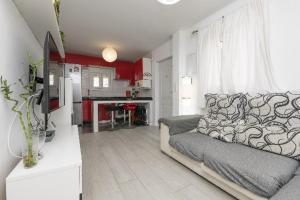 uma sala de estar com um sofá e uma cozinha em AMANECER BOUTIQUE HOME, BEACH, Village & RELAX em Chiclana de la Frontera