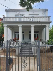 una casa blanca con una valla delante en STUDIO VIK en Soko Banja