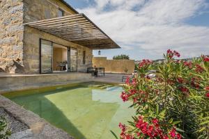 una piscina en el patio trasero de una casa con flores en Lemon House, en Valpedre