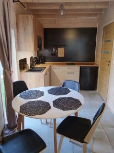 a kitchen with a table and chairs in a room at SOSNOWY KLIFF in Niechorze