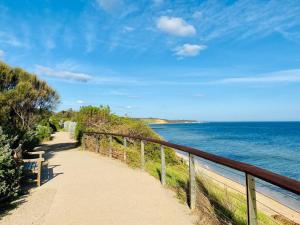 a path next to the ocean with a fence at Bay Rd Kids & Pet Friendly Free Parking in Cheltenham +6 photos