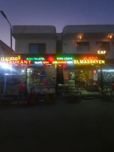 a store with neon signs in front of a building at Luna House Lighthouse in Dahab