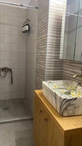 a bathroom with a sink and a shower with a mirror at ChrysPa, sea view apartment in Souda