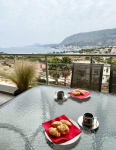 a table with two plates of donuts on a balcony at ChrysPa, sea view apartment in Souda