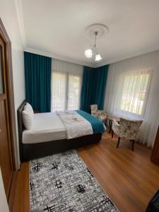 a bedroom with a bed and a table and chairs at Uzungol Soylu Hotel in Uzungöl