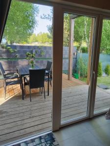 a sliding glass door leading to a deck with a table and chairs at SOSNOWY KLIFF in Niechorze