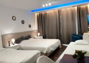 um quarto de hotel com duas camas e uma luz azul em Luxury Apartment No. 202 (Napa Ace) em Agia Napa