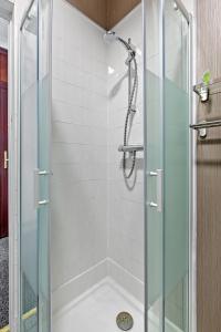 a shower with a glass door in a bathroom at Bella Casa two in Largs