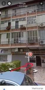 a building with a red arrow in front of it at הברון baron in Rishon LeẔiyyon
