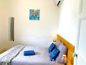 a bedroom with a bed with blue pillows at Blue Summer Vibes Apartment for 4P, AC, balcony, parking, beach at 50m, SPA access -4 in La Ciotat