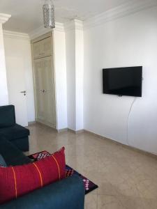 a living room with a couch and a television on a wall at Cozy apartment in Tanger in Tangier