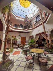 vestíbulo con mesa, sillas y techo de cristal en Riad Chennaoui, en Marrakech