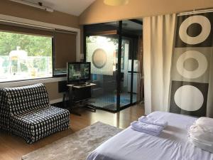 ein Schlafzimmer mit einem Bett, einem Stuhl und einem TV in der Unterkunft Mitra @Guesthouse B28-S in Batam Center