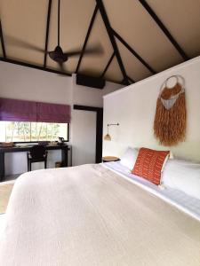 um quarto com uma grande cama branca e uma secretária em Jade cottages em Koh Samui 